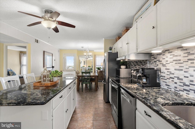 kitchen with ceiling fan with notable chandelier, a healthy amount of sunlight, and white cabinets