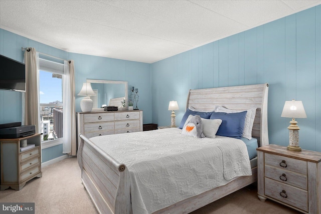 bedroom featuring light colored carpet and a textured ceiling