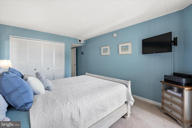 bedroom with light carpet and a closet