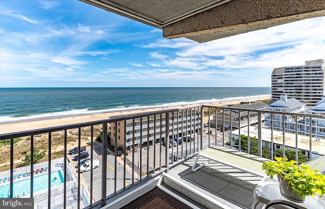 balcony featuring a water view and a view of the beach