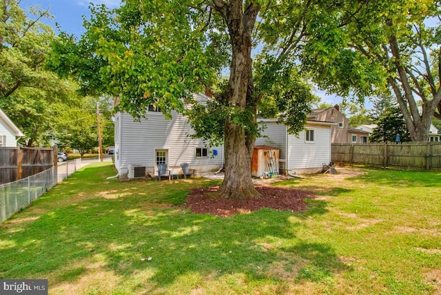 back of property with a yard and central air condition unit