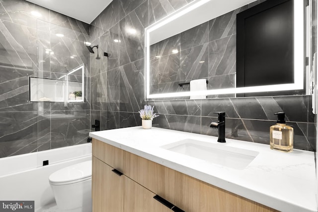 full bathroom featuring vanity, backsplash, tile walls, toilet, and tiled shower / bath