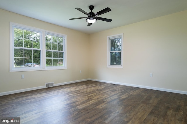 spare room featuring a ceiling fan, dark wood-type flooring, baseboards, and visible vents