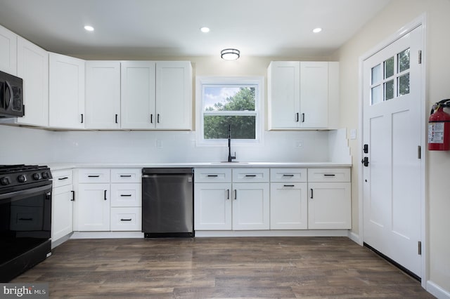 kitchen featuring black range with electric stovetop, dark hardwood / wood-style flooring, dishwasher, sink, and white cabinetry