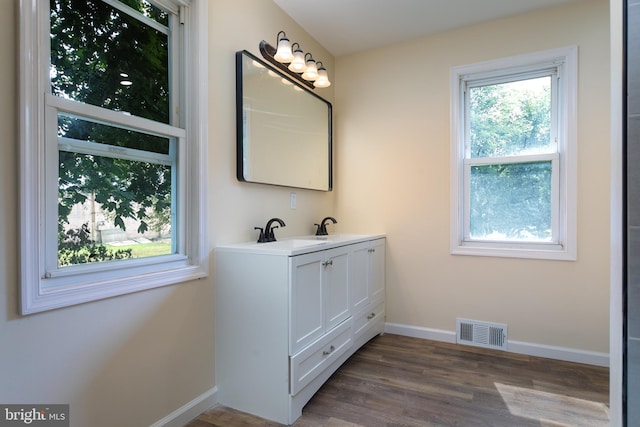 bathroom featuring visible vents, baseboards, wood finished floors, and vanity