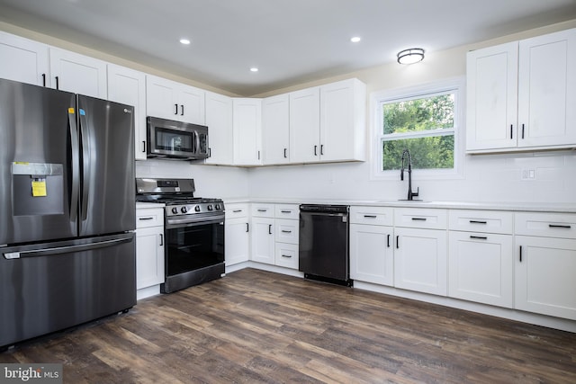 kitchen featuring dark wood-style floors, recessed lighting, a sink, stainless steel appliances, and white cabinetry