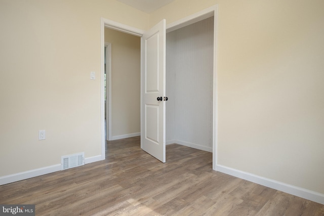 empty room featuring visible vents, baseboards, and light wood-style floors