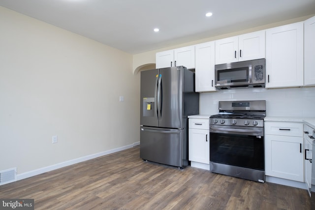 kitchen featuring backsplash, white cabinets, stainless steel appliances, and light countertops