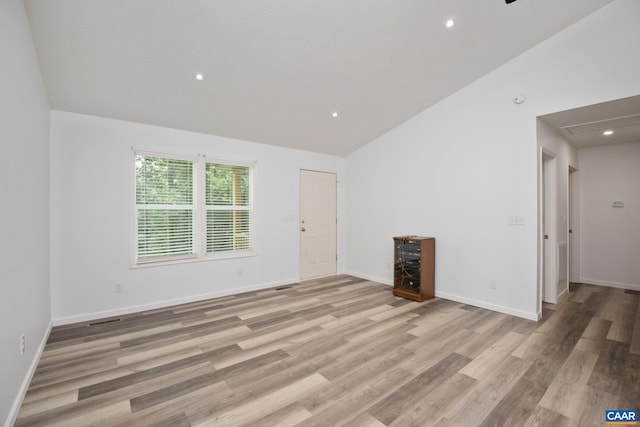 unfurnished living room featuring lofted ceiling and light hardwood / wood-style flooring