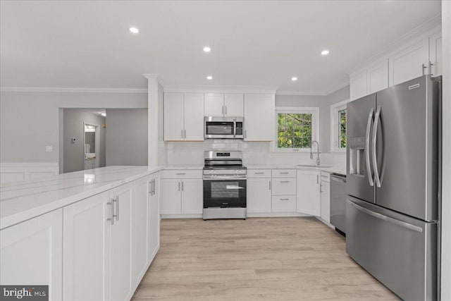 kitchen featuring a sink, tasteful backsplash, white cabinetry, and stainless steel appliances