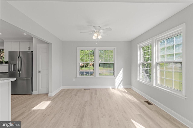 interior space featuring visible vents, light wood-type flooring, and baseboards