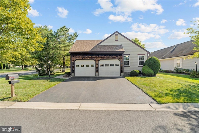 view of front facade with a front lawn, an attached garage, driveway, and a shingled roof