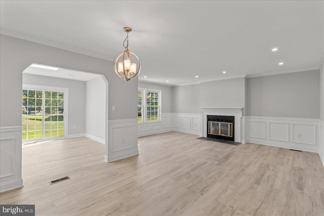 unfurnished living room with visible vents, crown molding, a fireplace with flush hearth, recessed lighting, and light wood-style flooring