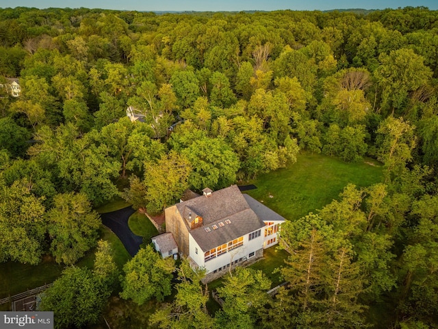 birds eye view of property featuring a forest view