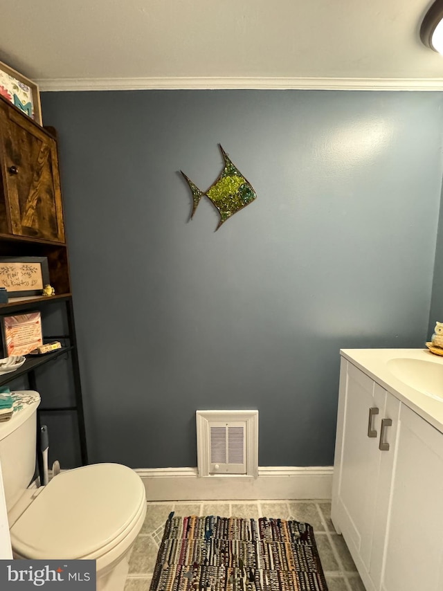 bathroom with vanity, toilet, and ornamental molding