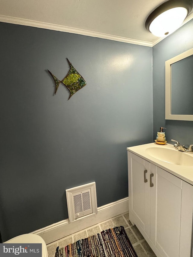 bathroom with toilet, ornamental molding, and vanity