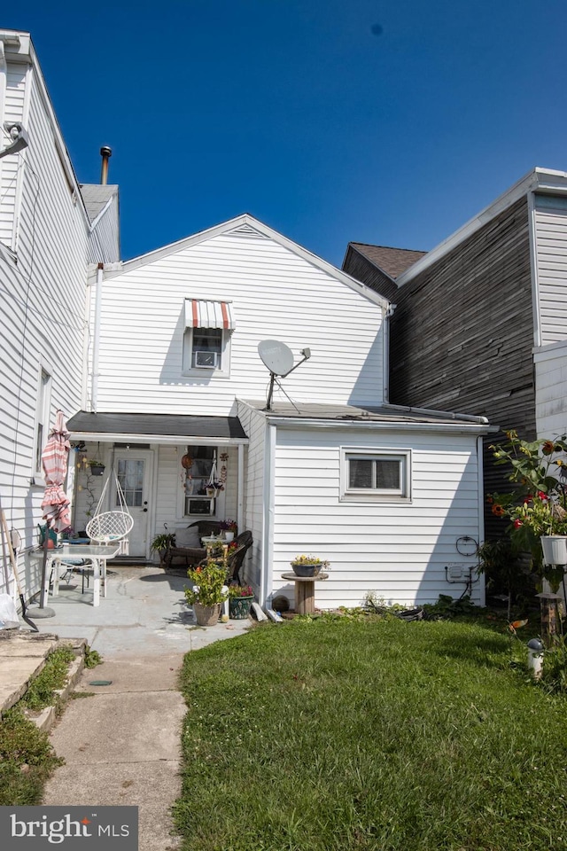 rear view of property featuring a yard and a patio area