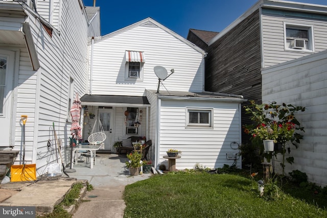 rear view of property featuring a yard and a patio