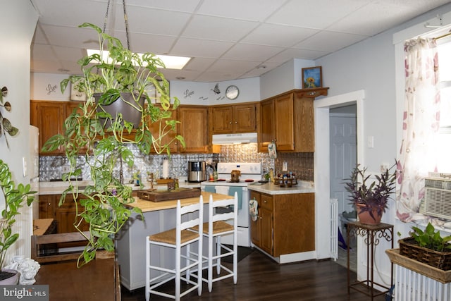 kitchen featuring dark wood-type flooring, tasteful backsplash, a paneled ceiling, and electric stove