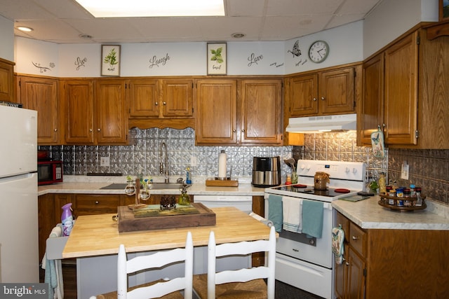 kitchen with white appliances, backsplash, and sink