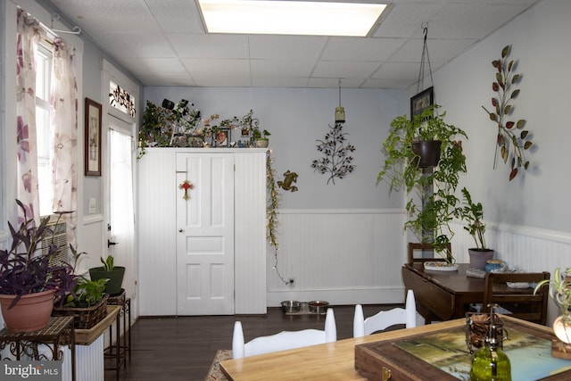 dining area with a paneled ceiling and dark hardwood / wood-style floors