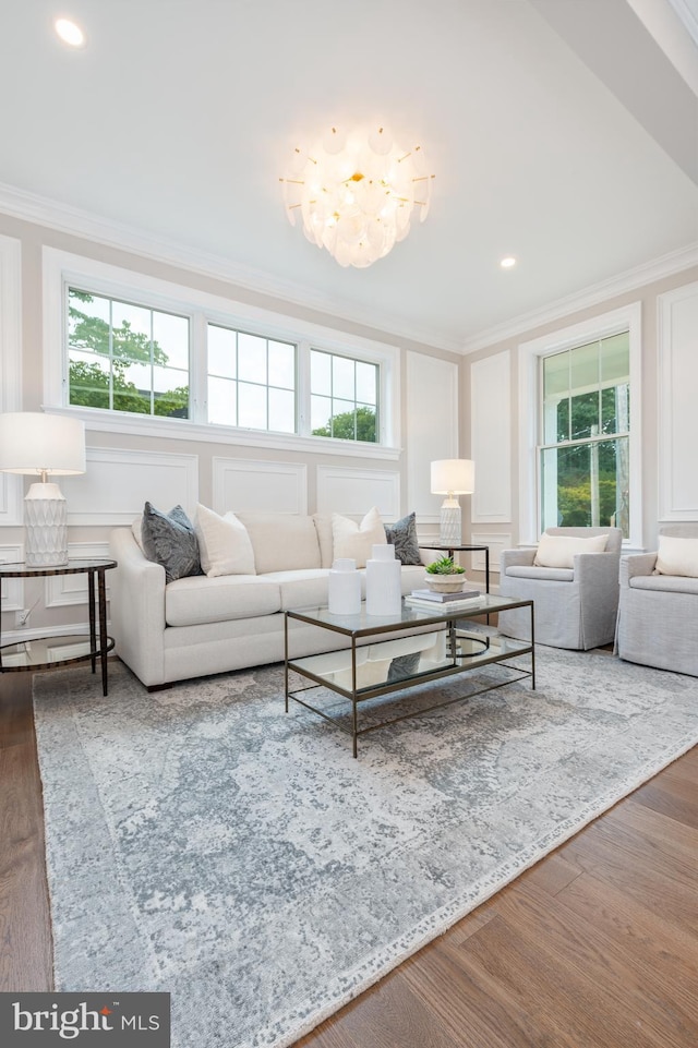 living room with ornamental molding, hardwood / wood-style flooring, and a notable chandelier