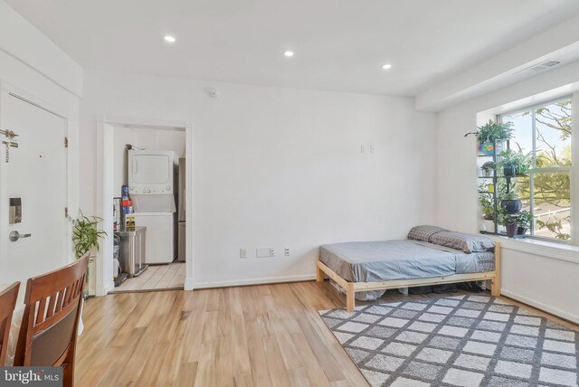 kitchen with light wood-type flooring, appliances with stainless steel finishes, white cabinetry, and decorative backsplash