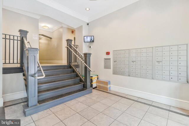 staircase with crown molding, mail boxes, and tile patterned flooring