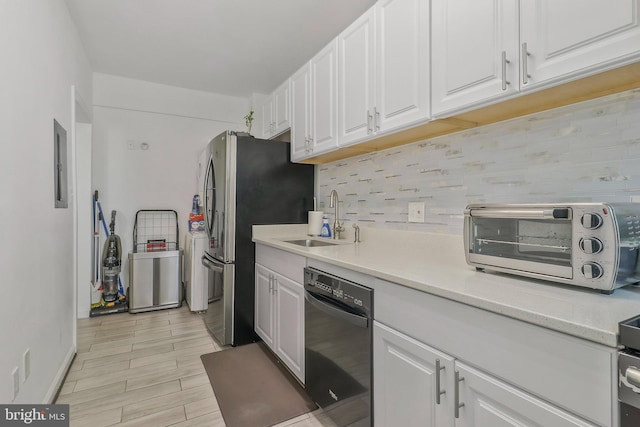 kitchen with stainless steel refrigerator, white cabinetry, sink, decorative backsplash, and light hardwood / wood-style floors