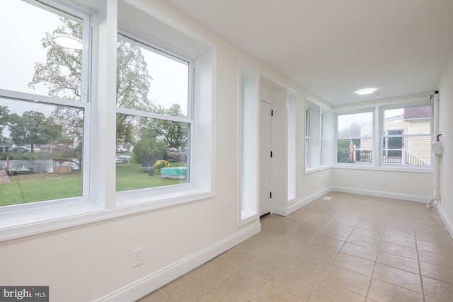 unfurnished room featuring light tile patterned floors and plenty of natural light