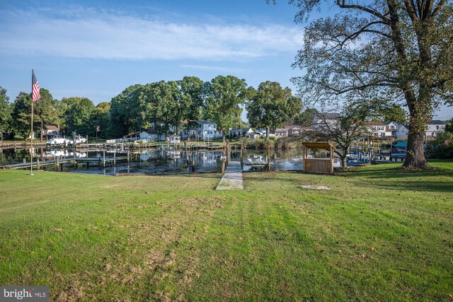 view of yard featuring a water view and a dock