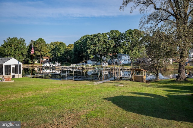 view of yard with a water view and a boat dock