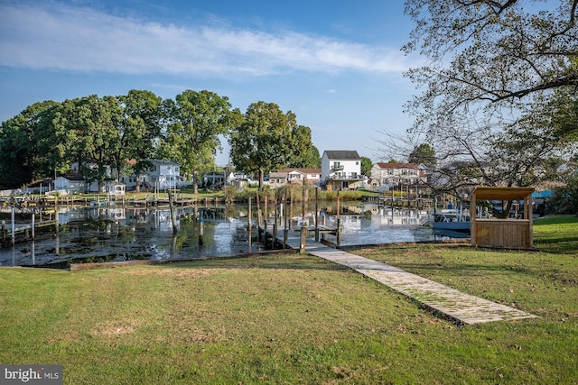 dock area featuring a water view and a lawn