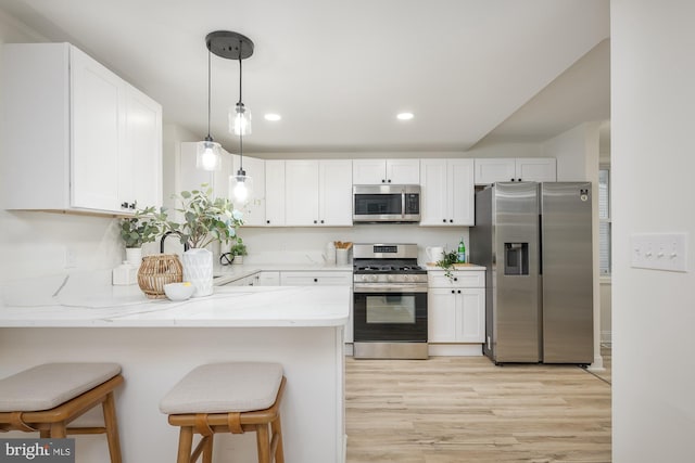 kitchen featuring white cabinetry, stainless steel appliances, and light wood-type flooring