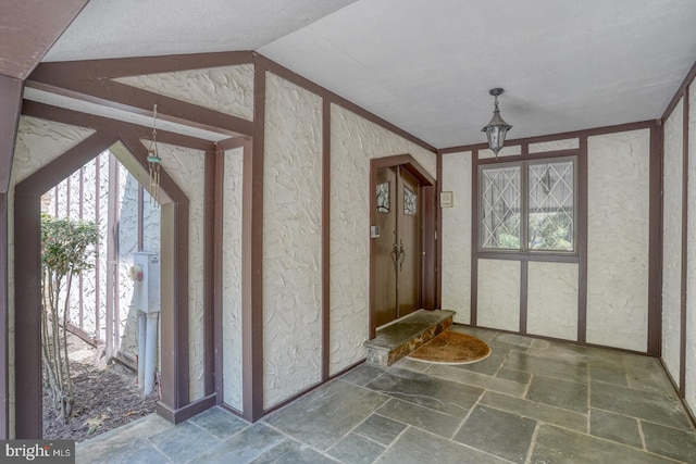 foyer with lofted ceiling and a textured ceiling