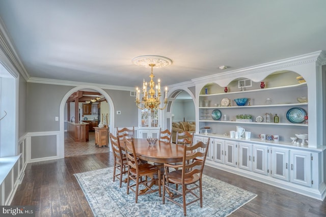 dining room featuring dark wood-type flooring, a chandelier, and crown molding