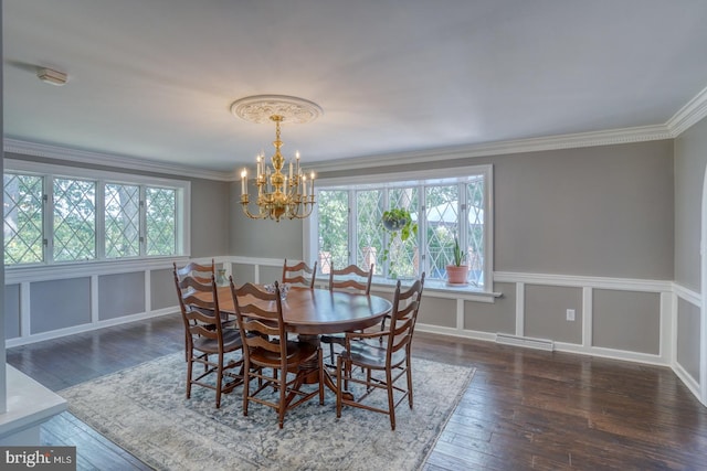 dining area with dark hardwood / wood-style floors, a chandelier, and crown molding