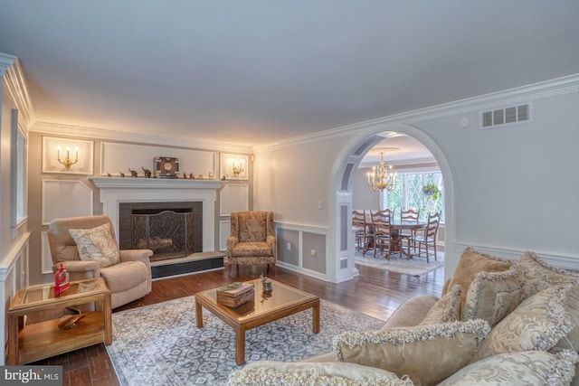 living room with hardwood / wood-style floors, a notable chandelier, and ornamental molding