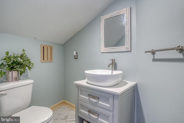 bathroom with lofted ceiling, vanity, and toilet