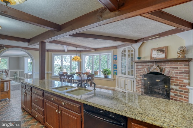 kitchen featuring a fireplace, black dishwasher, a healthy amount of sunlight, and sink