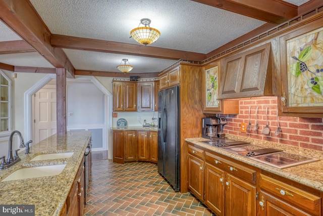 kitchen with tasteful backsplash, sink, black fridge with ice dispenser, custom exhaust hood, and light stone counters