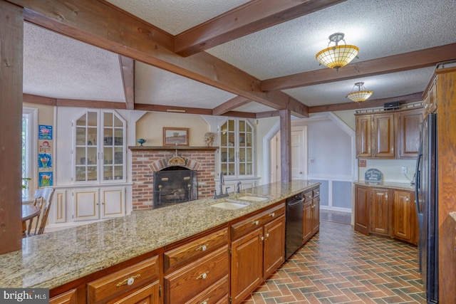 kitchen featuring black appliances, light stone countertops, a fireplace, and a textured ceiling