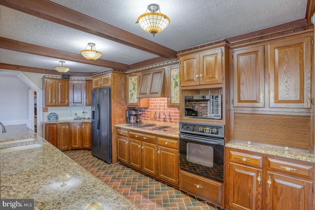 kitchen with black appliances, light stone countertops, sink, and decorative backsplash