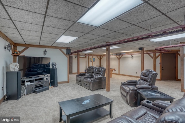 living room featuring carpet floors and a drop ceiling