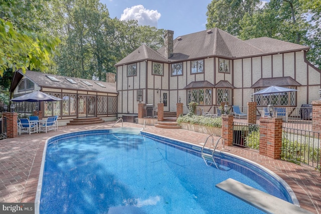 view of pool featuring a gazebo, a diving board, and a patio