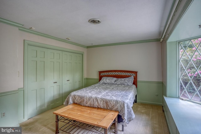 bedroom with crown molding and a closet