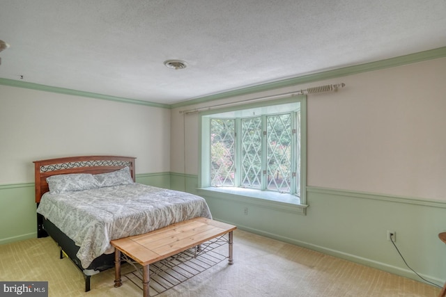 bedroom featuring ornamental molding, a textured ceiling, and light colored carpet