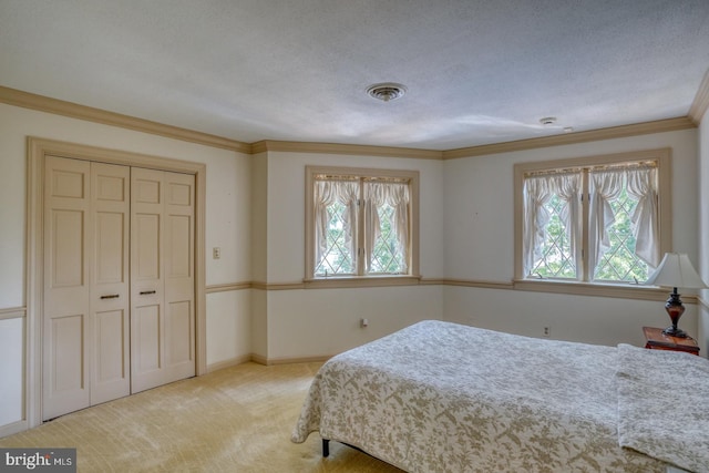 carpeted bedroom with ornamental molding, multiple windows, a textured ceiling, and a closet