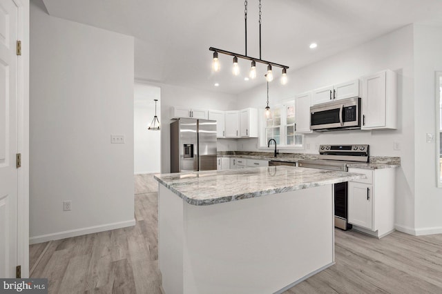 kitchen with white cabinetry, light wood finished floors, and stainless steel appliances