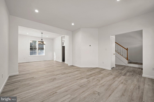 unfurnished living room with recessed lighting, stairway, a notable chandelier, and light wood finished floors